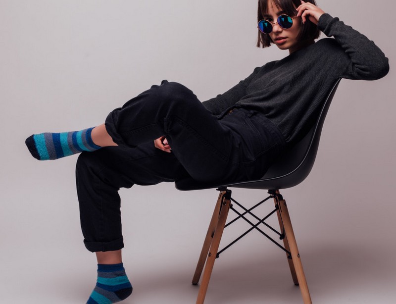 jeune femme assise portant fierement une paire de chaussettes